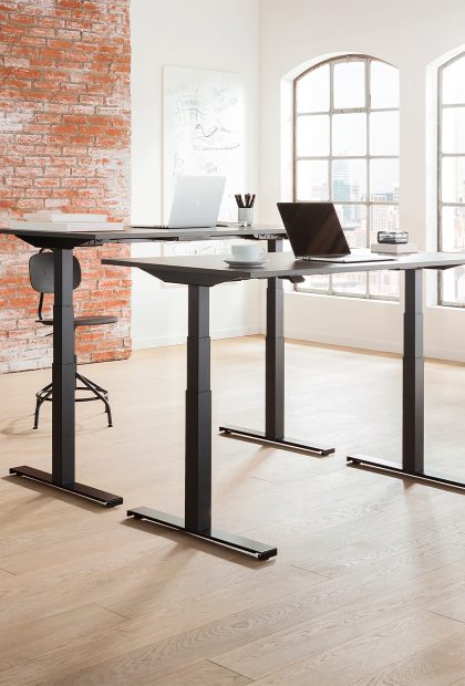 Office with office workers at ergonomic sit-stand desks